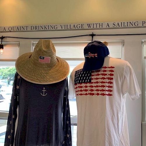 Two mannequins dressed in nautical-themed clothing and hats stand under a sign that reads 